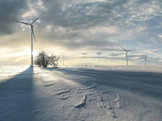 Bewölkte Schneelandschaft in Mont Crosin mit Windkraftwerk von Juvent